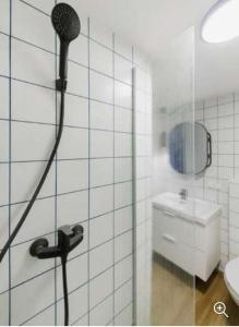 考纳斯Stay in Kaunas & LA51 - Free Parking的带淋浴和盥洗盆的白色瓷砖浴室