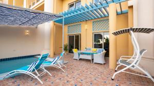 迪拜Exclusive Retreat GLOBALSTAY's New 3BR Townhouse with Private Pool的一个带桌椅的庭院和一个游泳池