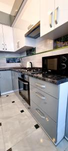 捷尔诺波尔Центр Апарт的一间配备了不锈钢用具和白色橱柜的大厨房