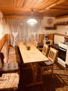 Valašská BystřiceÚtulná chaloupka na Valašsku的厨房配有木桌、椅子和沙发