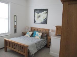 赖德Lovely Spacious 3 Bedded First Floor Apartment的一间卧室配有一张带蓝色枕头的床。