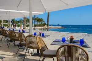 伊维萨镇Hotel Vibra Marítimo的海滩上的桌椅和遮阳伞