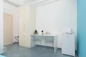 索伦托Guest House Emily Suites Sorrento的白色的客房配有桌椅和冰箱。