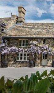 巴恩斯利Chantry House的一座石头建筑,上面有紫色的花朵