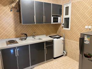 延布الشقق الذكية的一间带水槽和冰箱的小厨房