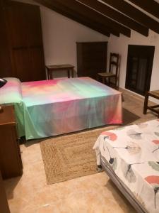皮萨拉Finca La Pimienta的一间卧室配有一张带彩虹床罩的床