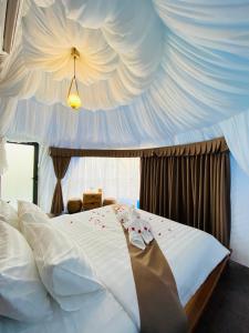 Véal VêngKravanh Camping Cardamom Mountain的卧室设有一张白色大床和天花板
