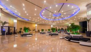 坎昆Seadust Cancun Family Resort - All Inclusive的大型大堂设有长沙发和大钟天花板