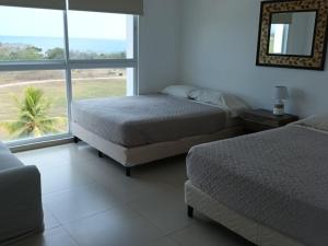 里奥阿托Playa Blanca Apartamentos的一间卧室设有两张床和大窗户