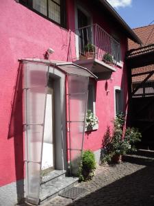 葡萄酒之路上的诺伊施塔特Winzeranwesen - Weingut Christian Eberley - Haupthaus I MINDESTAUFENTHALT 3 NÄCHTE - MINIMUM STAY 3 NIGHTS的粉红色的建筑,有门和一些植物