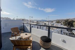 米克诺斯城She Mykonos - Luxury Apartments的屋顶上带桌椅的阳台