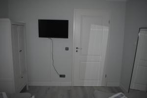 施托尔贝格Ferienwohnung JaRa 1的白色客房,墙上配有平面电视