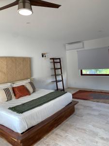 锡瓦塔塔内霍Luana suites- Suite Koya的一间卧室配有一张大床和木制床头板