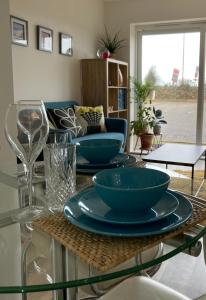 纽基Dog Friendly Stylish Modern Flat, near Beach的玻璃桌,上面有三个蓝色的碗