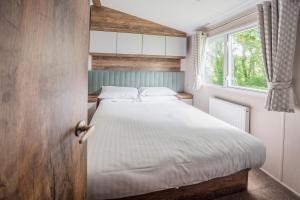 布德威德茅斯海湾大篷车公园度假村的一间卧室设有一张床和一个窗口