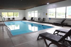 凯夫城山洞城康福特茵酒店&套房的一个带椅子和桌子的大型游泳池