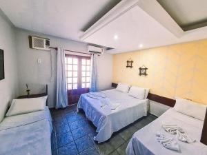 普拉亚弗朗西丝Hotel Pousada Mahon Mar的酒店客房设有两张床和窗户。