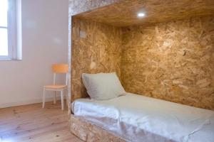 埃武拉Patinha Inn的石墙房间内的一张床位