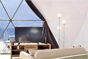 法亚·达·奥韦利亚Vi Naturae Glamping的帐篷内的客厅配有大屏幕电视