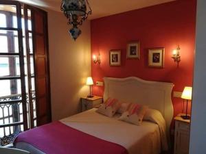 Villanueva de OscosHOTEL RURAL OSCOS的卧室配有白色的床铺和红色的墙壁