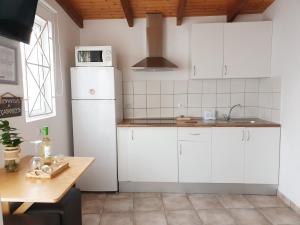 马斯帕洛马斯El Caramelito 1的厨房配有白色橱柜和白色冰箱。