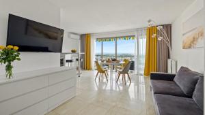 曼德琉-拉纳普勒Cannes Marina Appart Hotel Mandelieu的客厅配有电视和桌椅