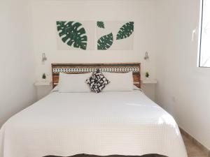 马斯帕洛马斯El Caramelito 1的白色卧室配有一张带白色床单的大床