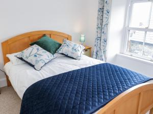 贝图瑟科伊德Dolwen的一间卧室配有一张带蓝色棉被和枕头的床