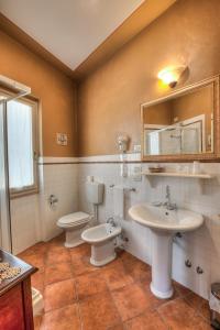 博尔戈圣洛伦索Hotel Locanda Degli Artisti的浴室设有2个卫生间、水槽和镜子