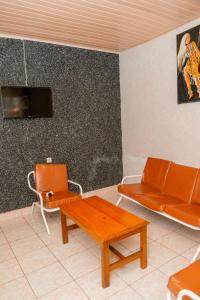 基加利Auberge La Caverne的客厅配有橙色沙发和桌子
