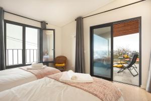 普拉泽里什Referta Apartamento T1的一间卧室设有一张床和一个大型玻璃窗