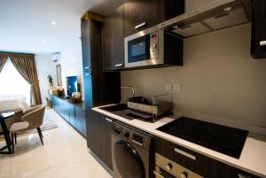 阿克拉Splendid Apartments @ The Lennox的厨房配有洗衣机和炉灶 顶部烤箱