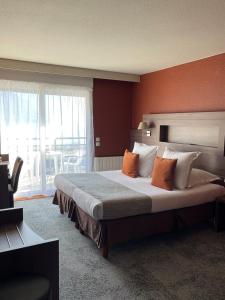 塞夫里耶Hôtel Beauregard, The Originals Relais (Inter-Hotel)的一间卧室配有一张带橙色墙壁的大床