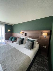塞夫里耶Hôtel Beauregard, The Originals Relais (Inter-Hotel)的一间卧室设有一张大床和绿色的墙壁