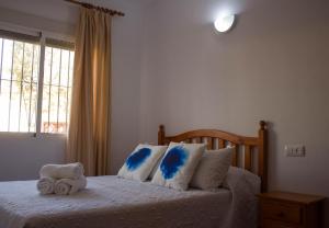 博罗尼亚Apartamentos Bellavista Bolonia的一间卧室配有一张带蓝色和白色枕头的床