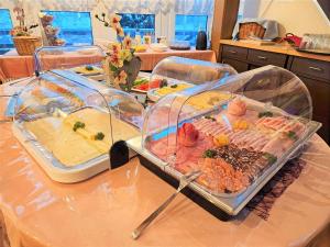 伦韦格地区诺伊豪斯Waldhotel Feldbachtal的一张桌子,上面放着几盘不同种类的食物