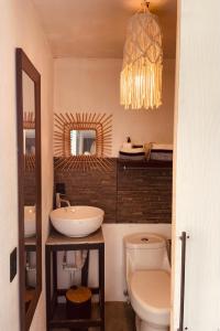 别霍港Casa Luce的一间带水槽、卫生间和吊灯的浴室