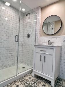 温斯洛普Winthrop Arms Hotel Restaurant Logan Airport的带淋浴、盥洗盆和镜子的浴室