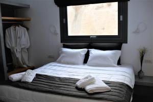 Éxo GoniáA Lux Villas Santorini的一间卧室配有一张床,上面有两条毛巾