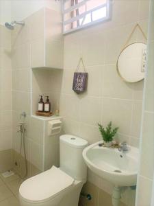 峇株巴辖Dedaun Homestay Batu Pahat的白色的浴室设有卫生间和水槽。