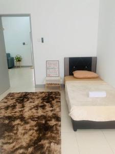 峇株巴辖Dedaun Homestay Batu Pahat的一间卧室配有一张床和地毯