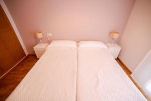 卡斯特利翁-德拉普拉纳Castellon Ribalta Apartments - Parking disponible的一间小卧室,配有两张床和两盏灯