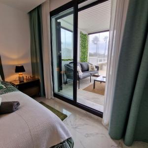 马拉加Casares del Mar Luxury Apartment的一间卧室设有一张床和一个滑动玻璃门