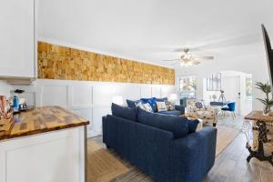 克利尔沃特Premier 2BD Waterfront Condo Barefoot Beach Resort的客厅配有蓝色的沙发和桌子