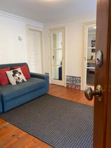 里斯本Cozy Estrela Apartment的客厅配有蓝色的沙发和地毯。