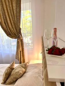 克兰内沃Villa Perla di Mare的一张带两个枕头的床和一张带酒杯的桌子
