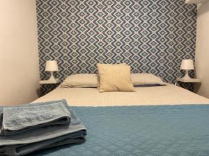 里斯本Cozy Estrela Apartment的一间卧室配有一张带蓝色毯子和墙壁的床。