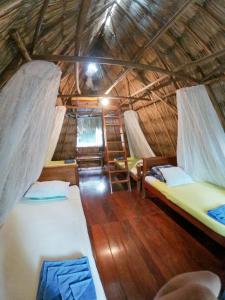 埃尔莱马特Posada del Cerro的稻草小屋内带两张床的房间