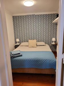 里斯本Cozy Estrela Apartment的一间卧室配有一张带蓝色图案墙壁的床