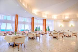 拉古纳Samba Laguna Tourist Hotel的用餐室设有桌椅和窗户。